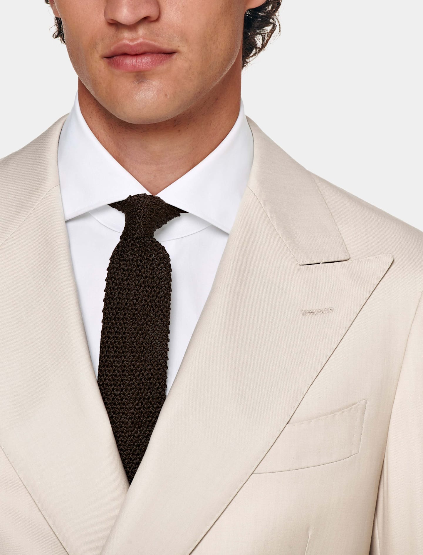 Light brown double-breasted suit and knitted tie.