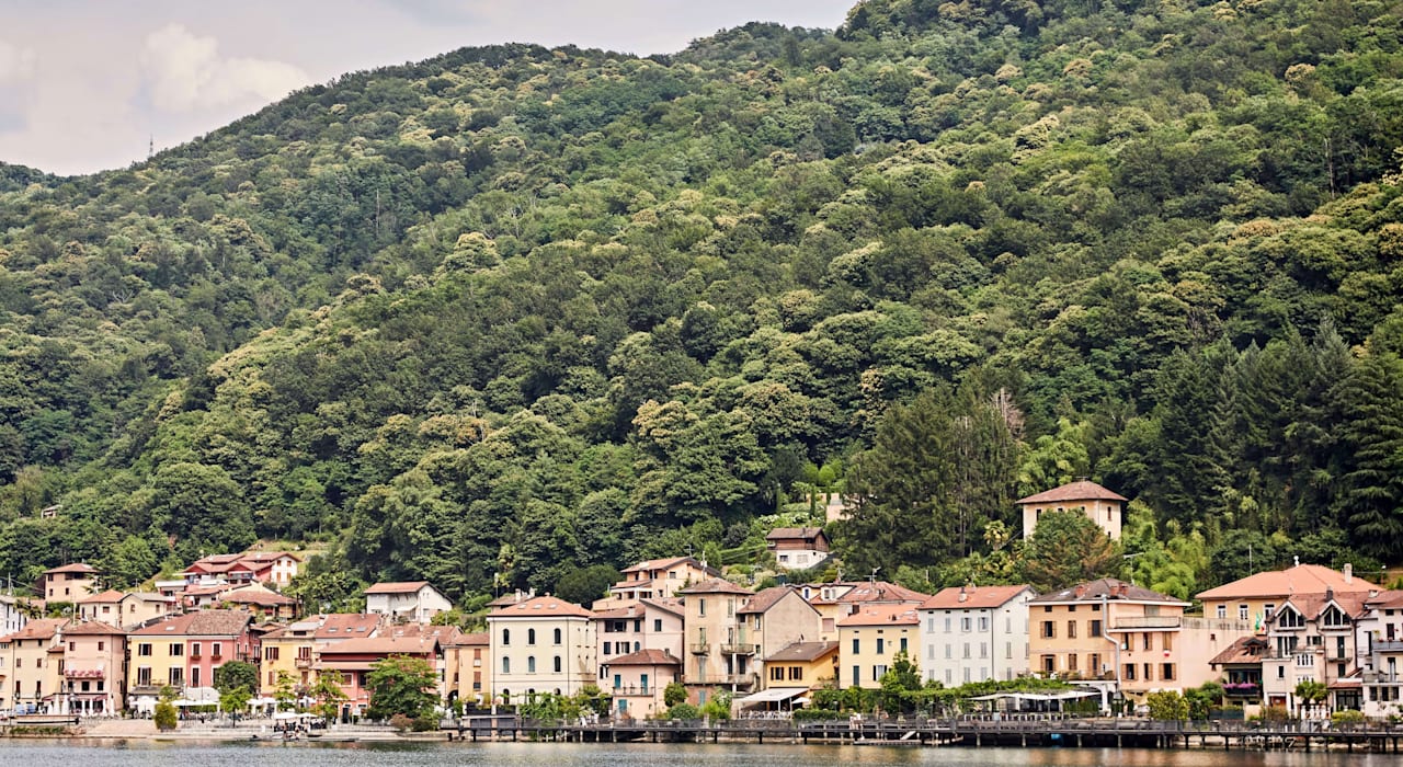 Lakeside Italian town with colorful buildings and lush green hills
