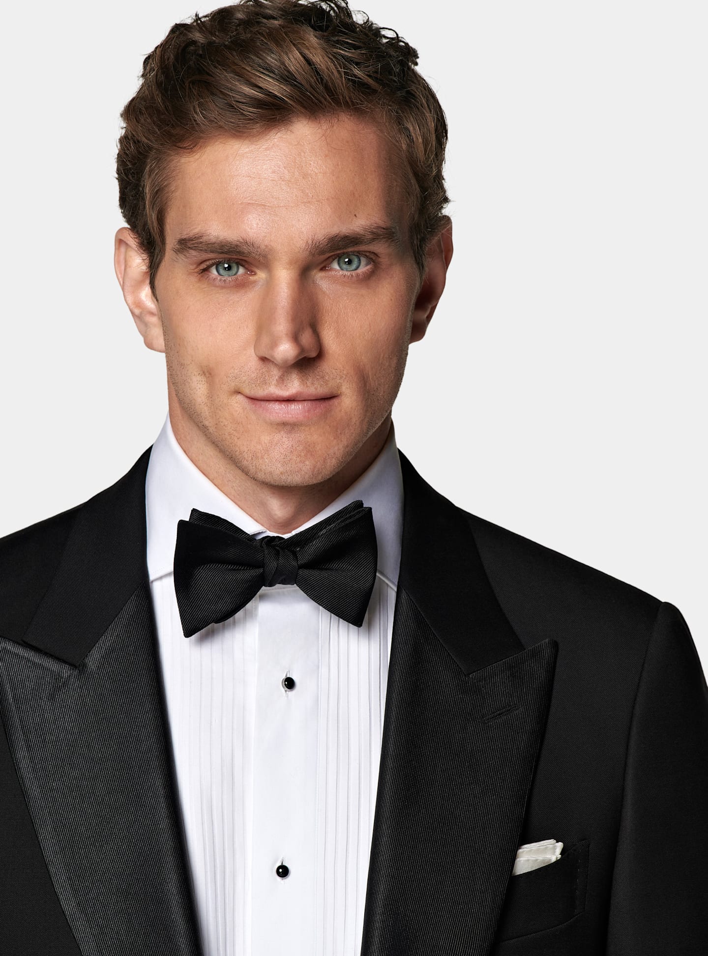 Tuxedo jacket with white pleated shirt and black bow tie.