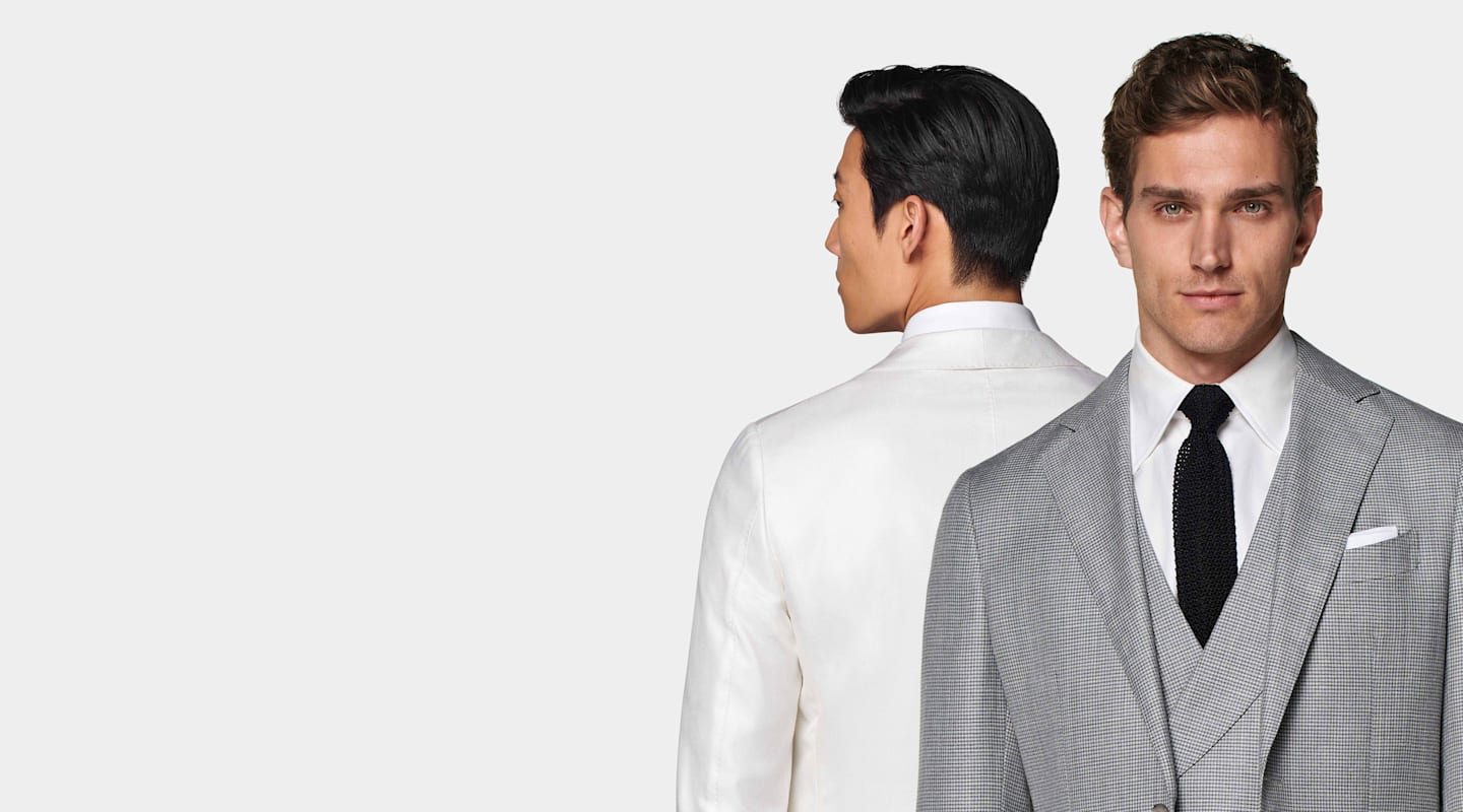 Dettaglio di giacca bianca e abito in 3 pezzi bianco e nero pied-de-poule con cravatta in maglia.