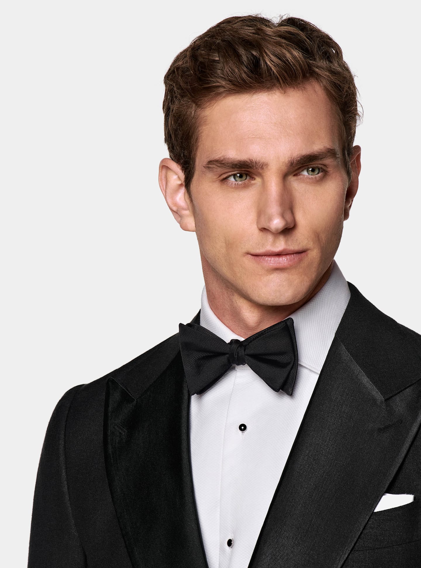 Black tuxedo for a black tie attire featuring a silk bowtie and stud buttons.