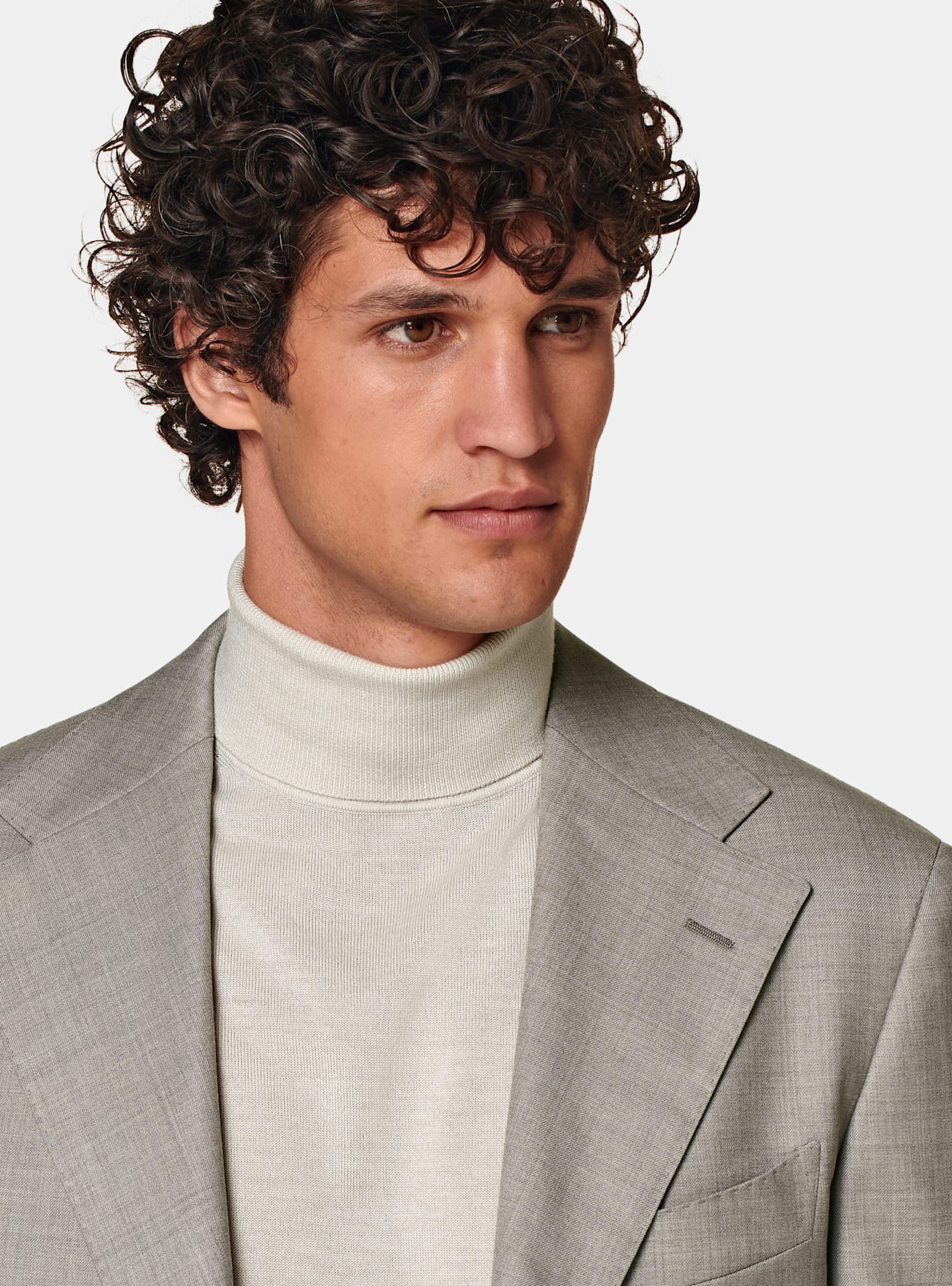 detail of taupe single-breasted suit with light taupe turtleneck.