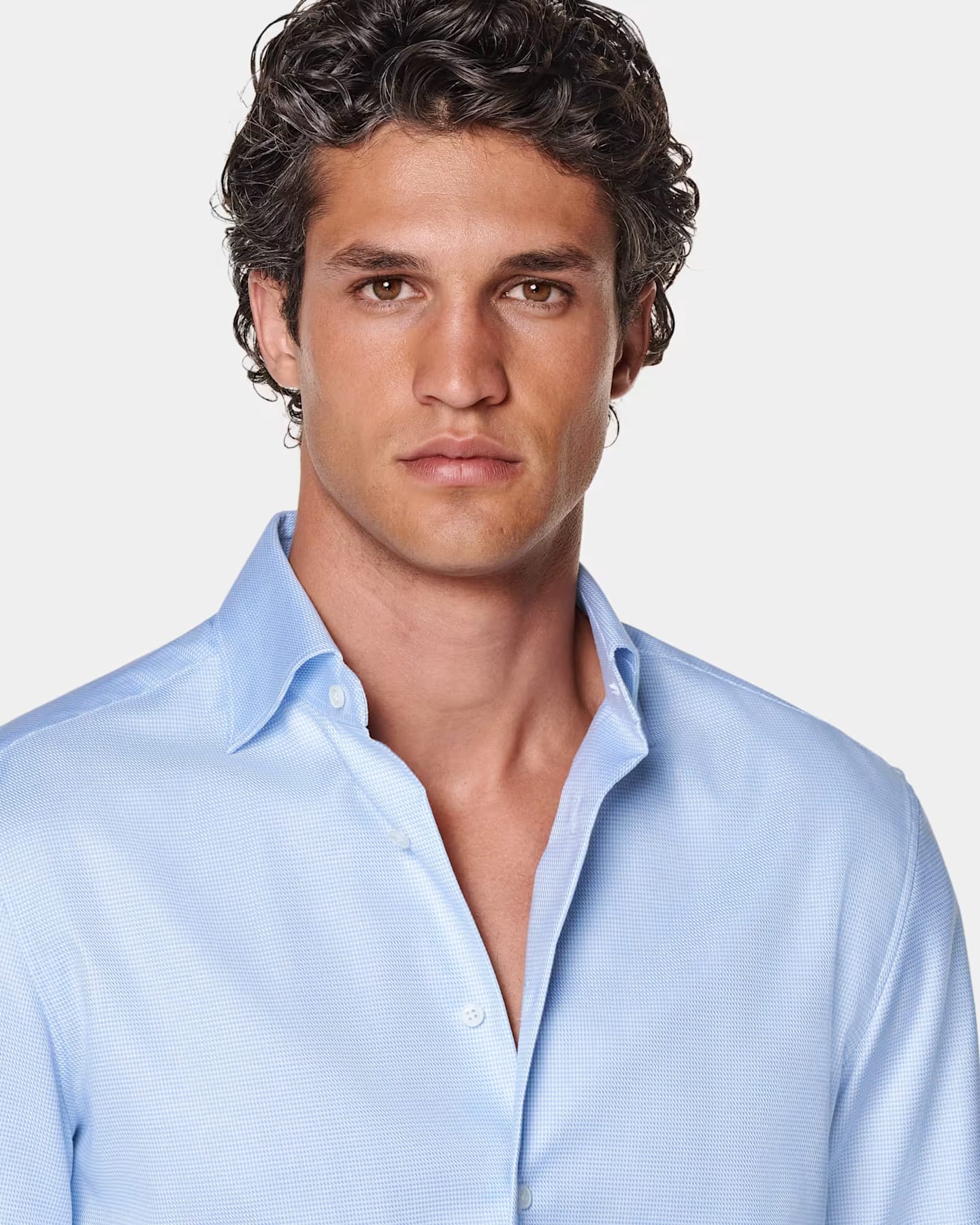 Wearing a light blue button-up shirt.