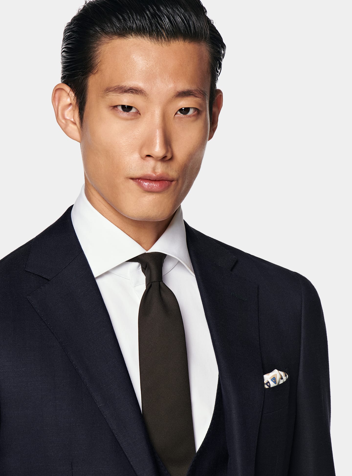 A zoomed in photo featuring a navy formal suit.