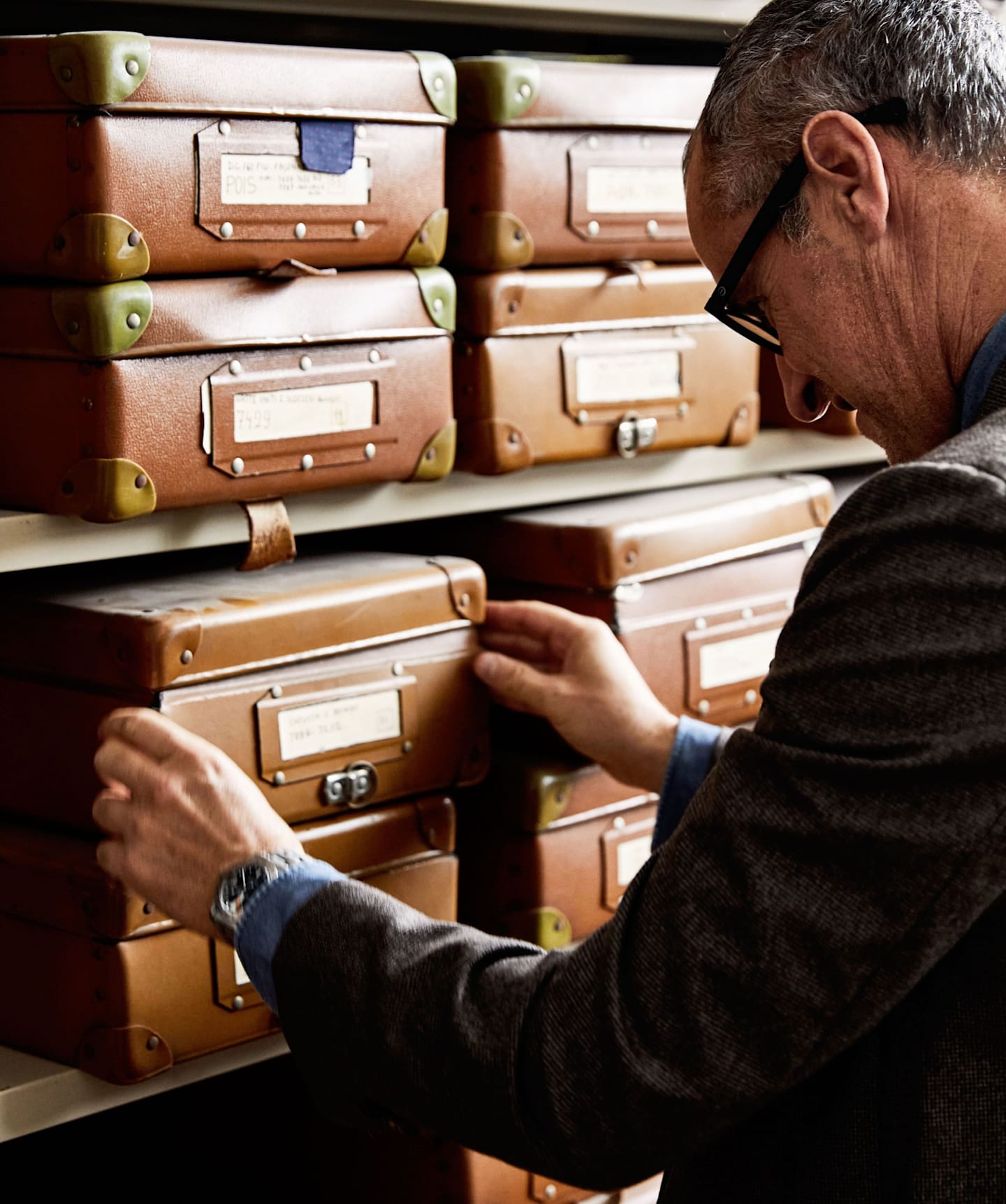 Man looking through Fossati archives to showcase historic fabrics.