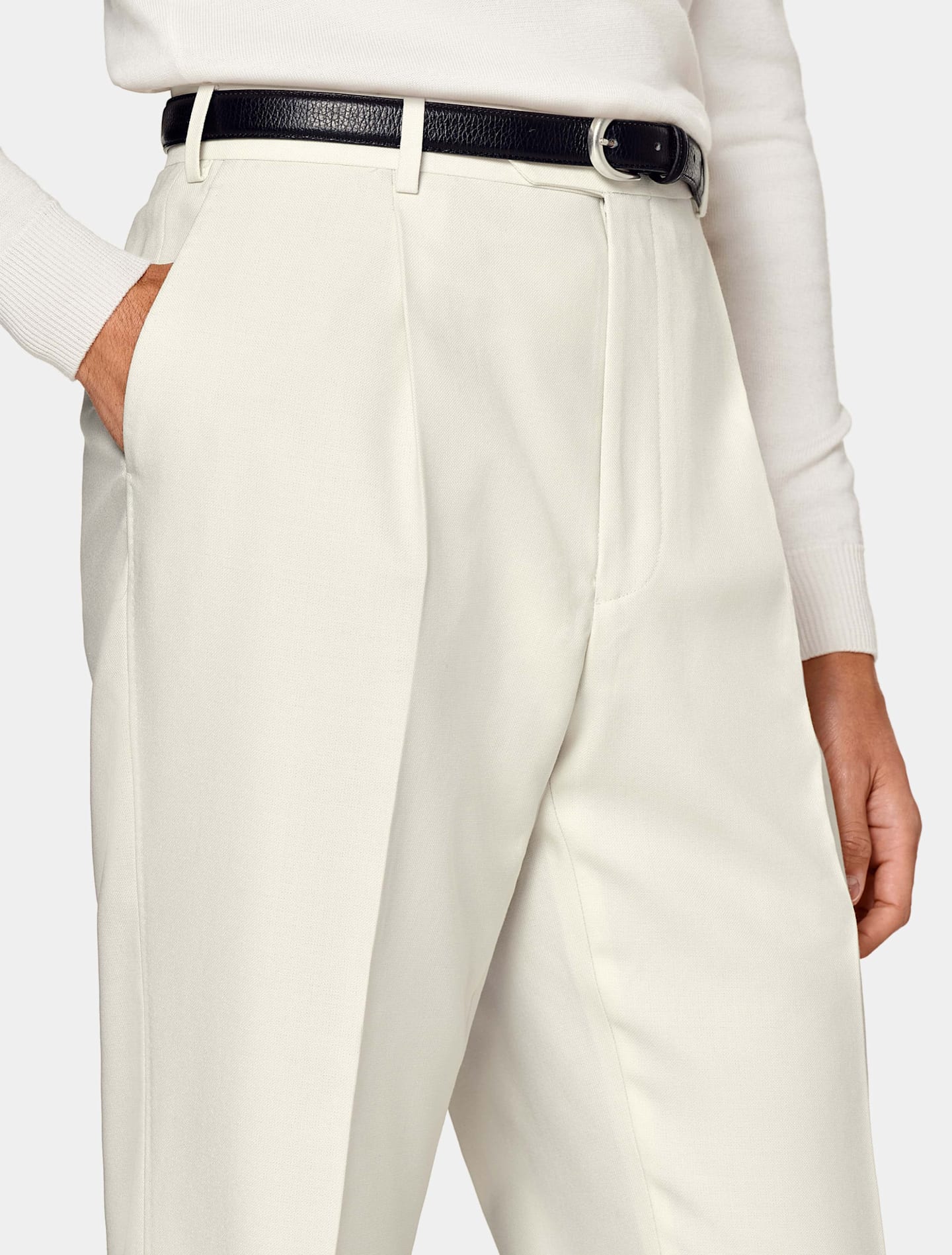 Off-white straight-fit trousers with black belt and white knit.