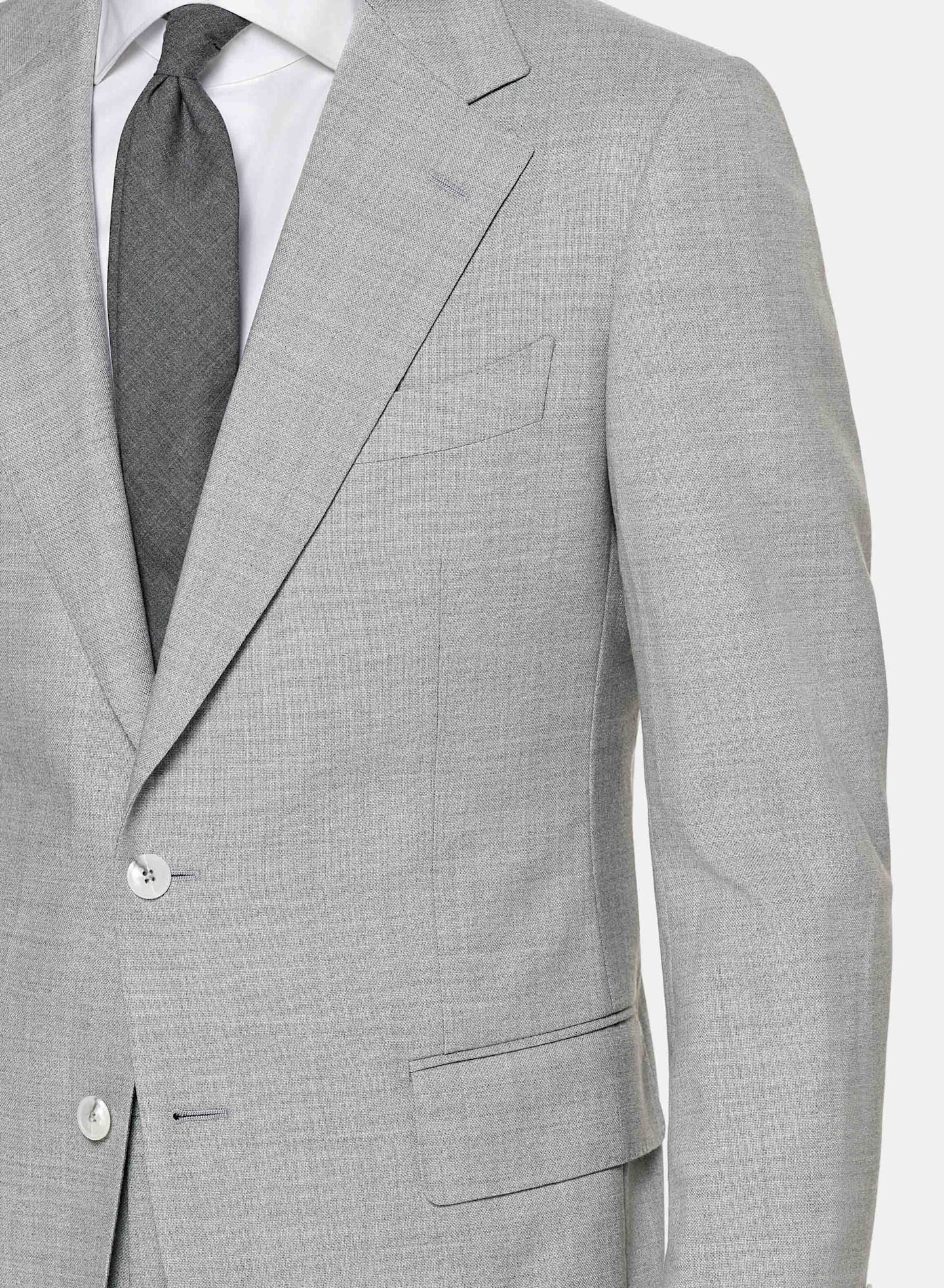 Grey suit with flap pockets and notch lapel, worn with white shirt and grey tie.