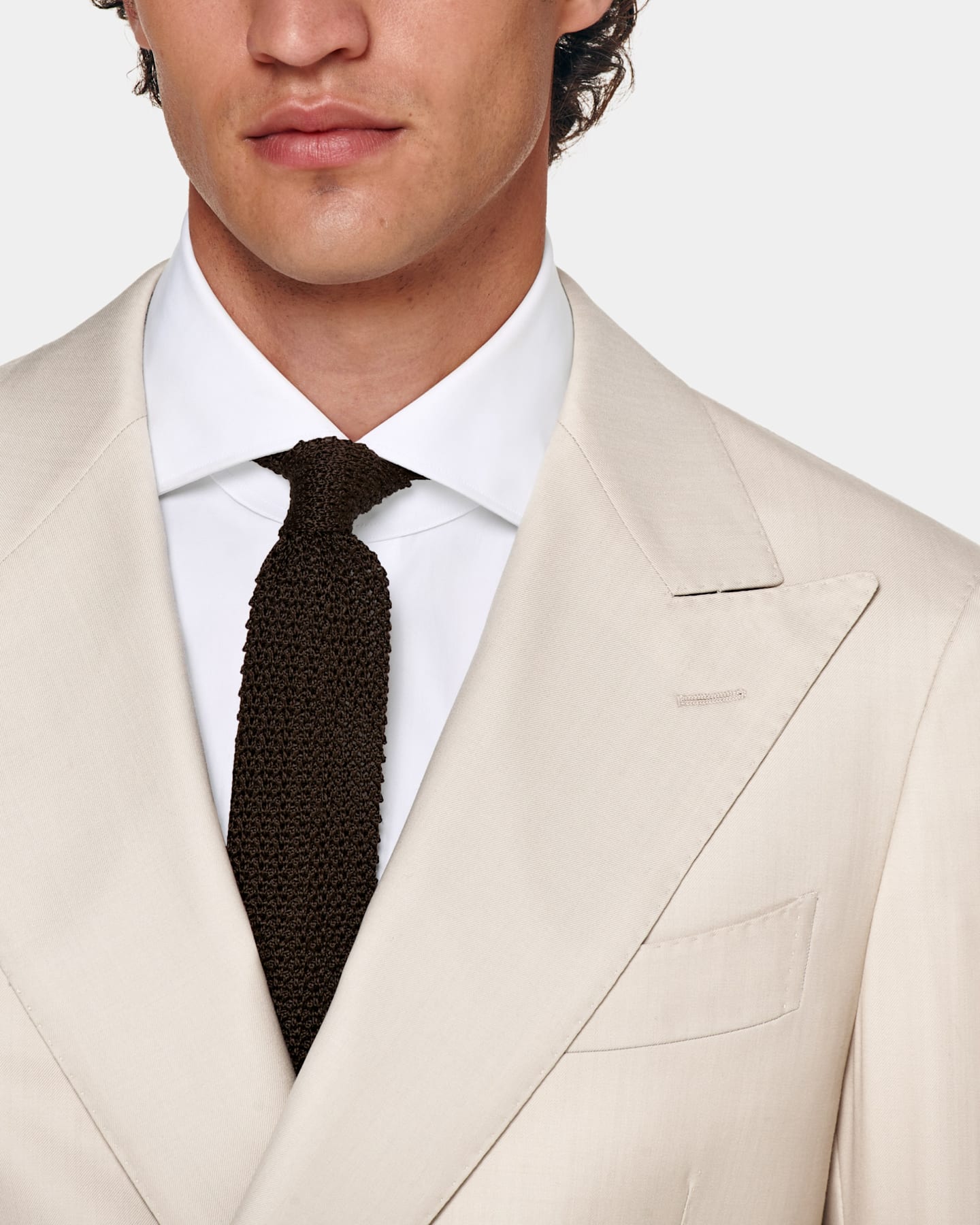 Light brown double-breasted suit and knitted tie.