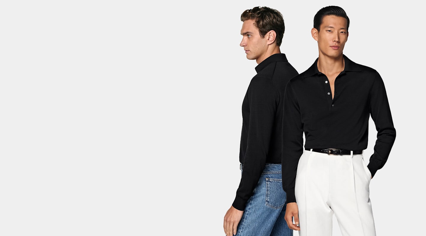 Two men styled in black polo shirts with jeans and white trousers