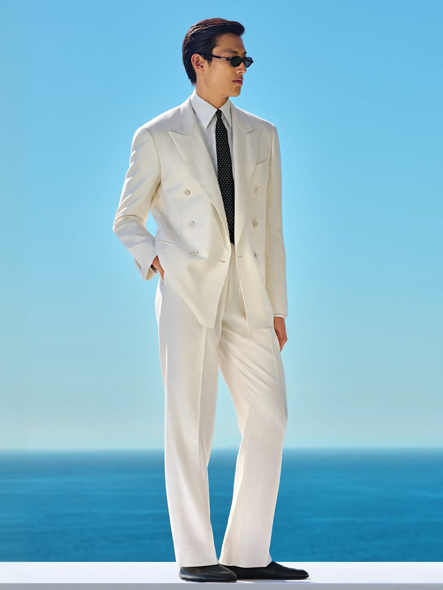Detail of light blue three-piece suit with white shirt and grey knitted silk tie.