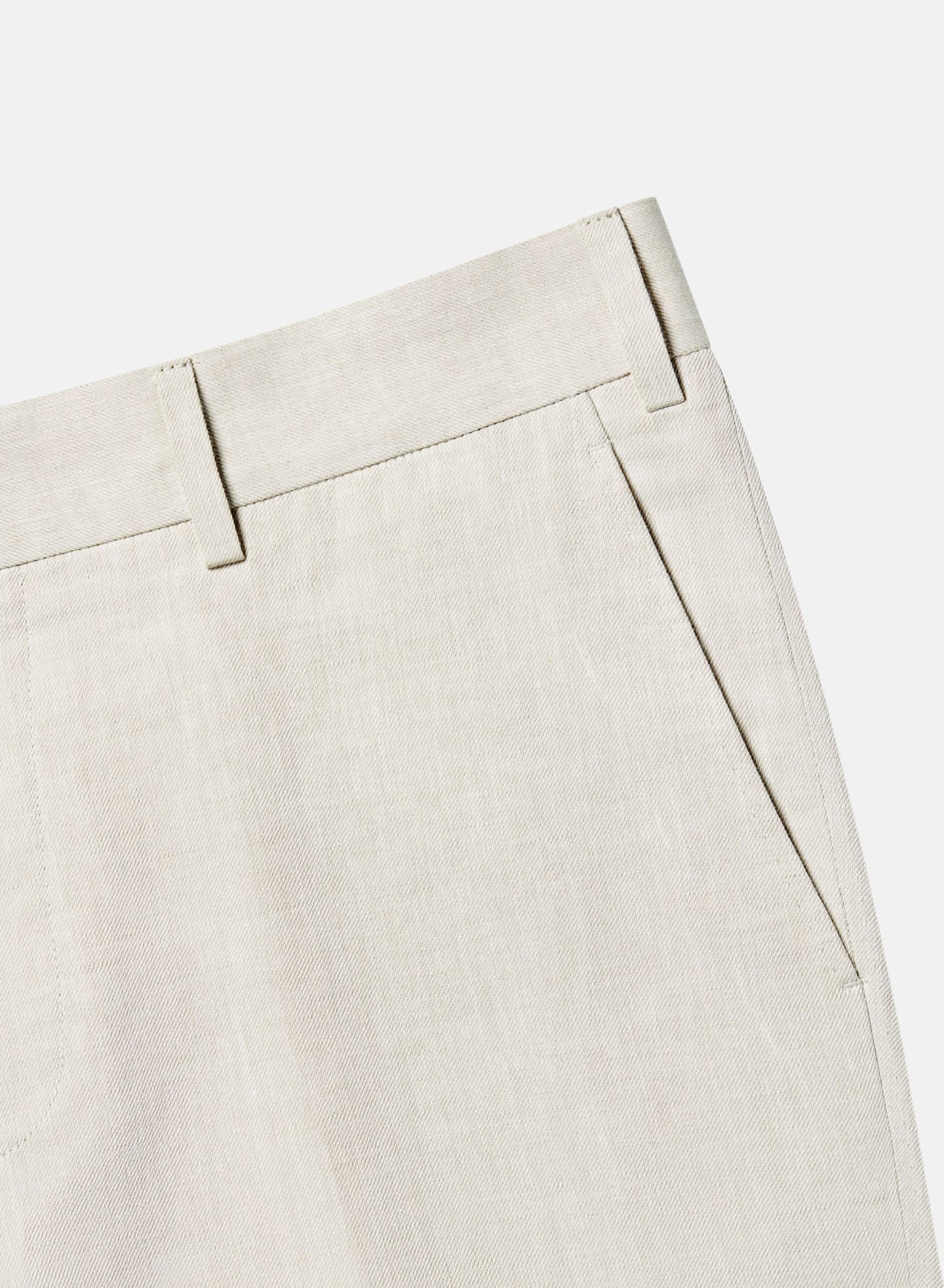 Flat front pocket on off-white linen pants.
