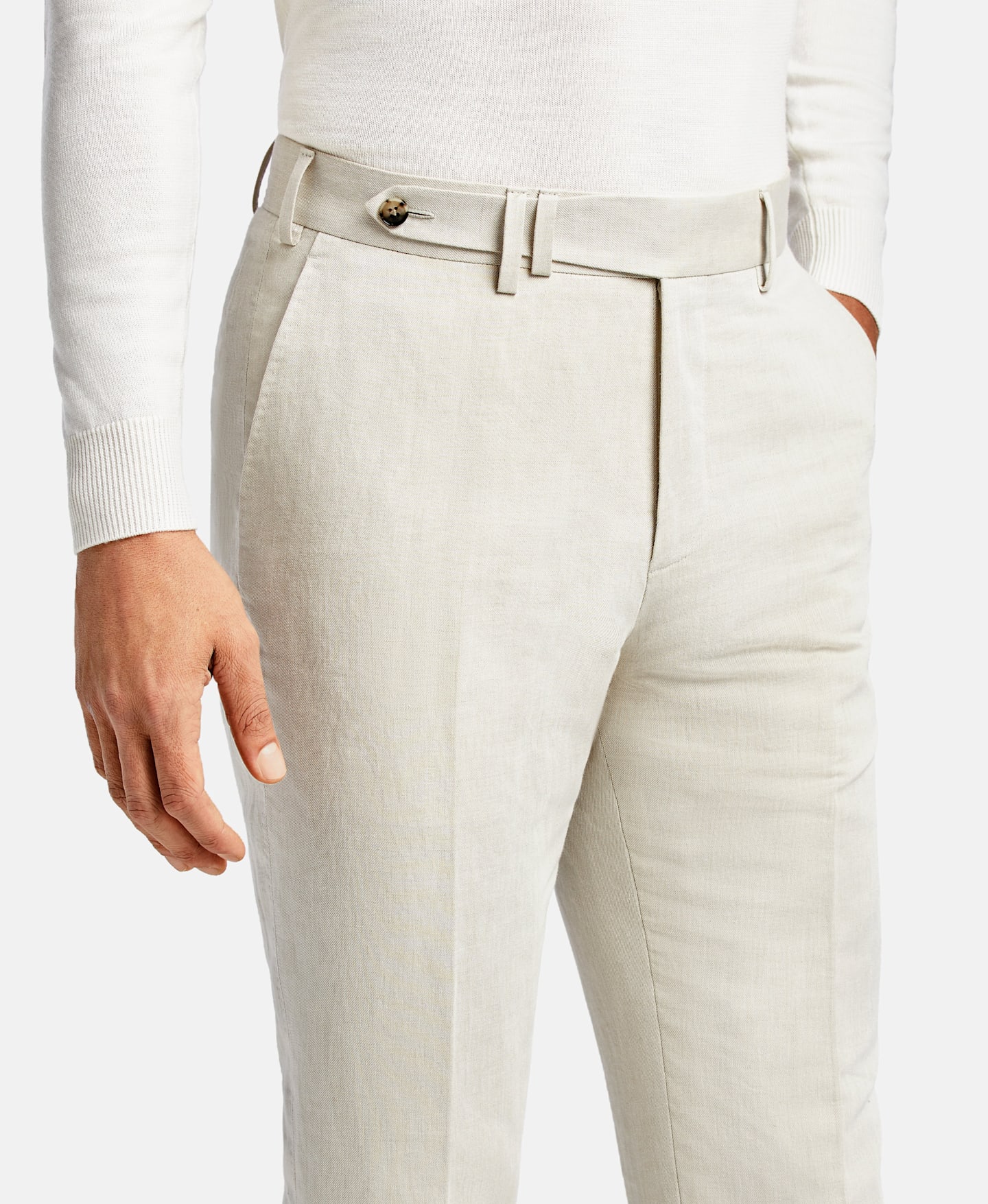 Flat front pocket on off-white linen pants.