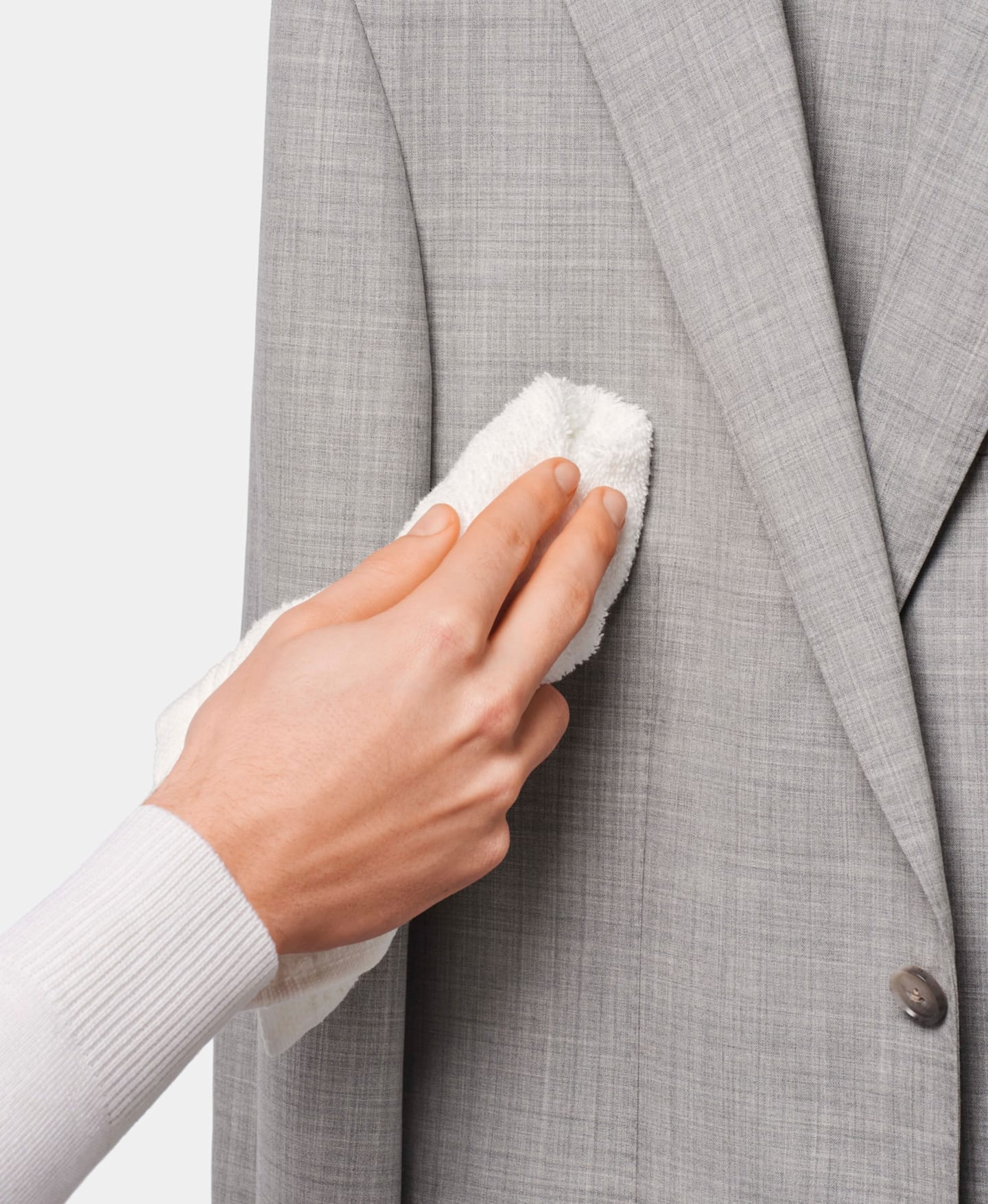 Smacchiatura di una giacca da abito grigio chiaro con un panno umido