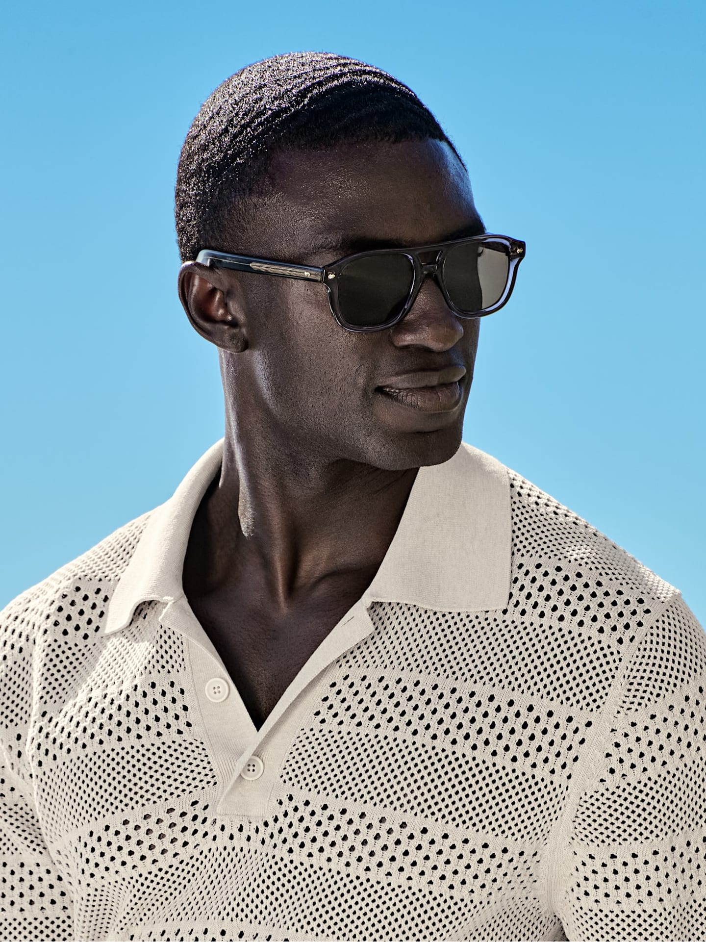 White open-knit polo shirt styled with sunglasses