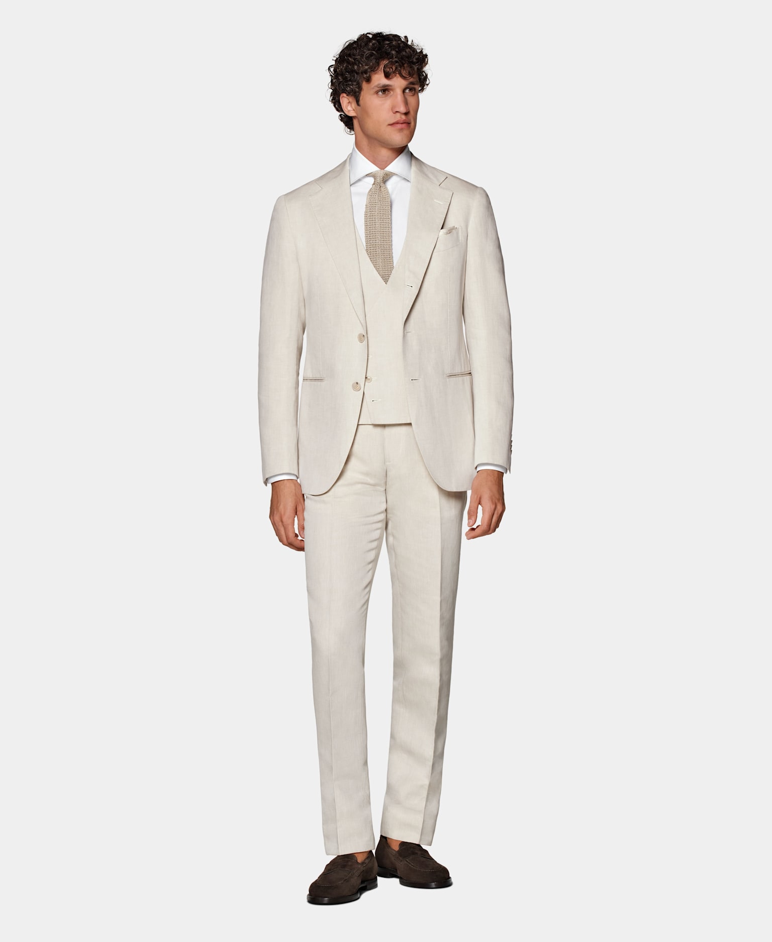Sommerhochzeit-Outfit für Herren: Hellbrauner dreiteiliger Anzug mit weißem Hemd und brauner Strickkrawatte aus Seide.