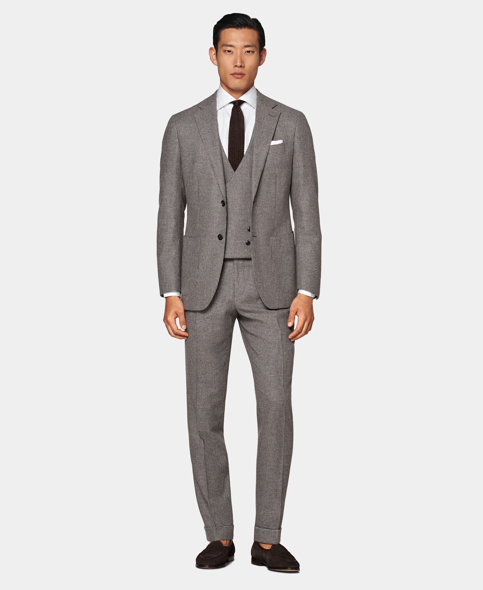 Houndstooth check 3-piece suit with a white shirt and brown silk knitted tie.