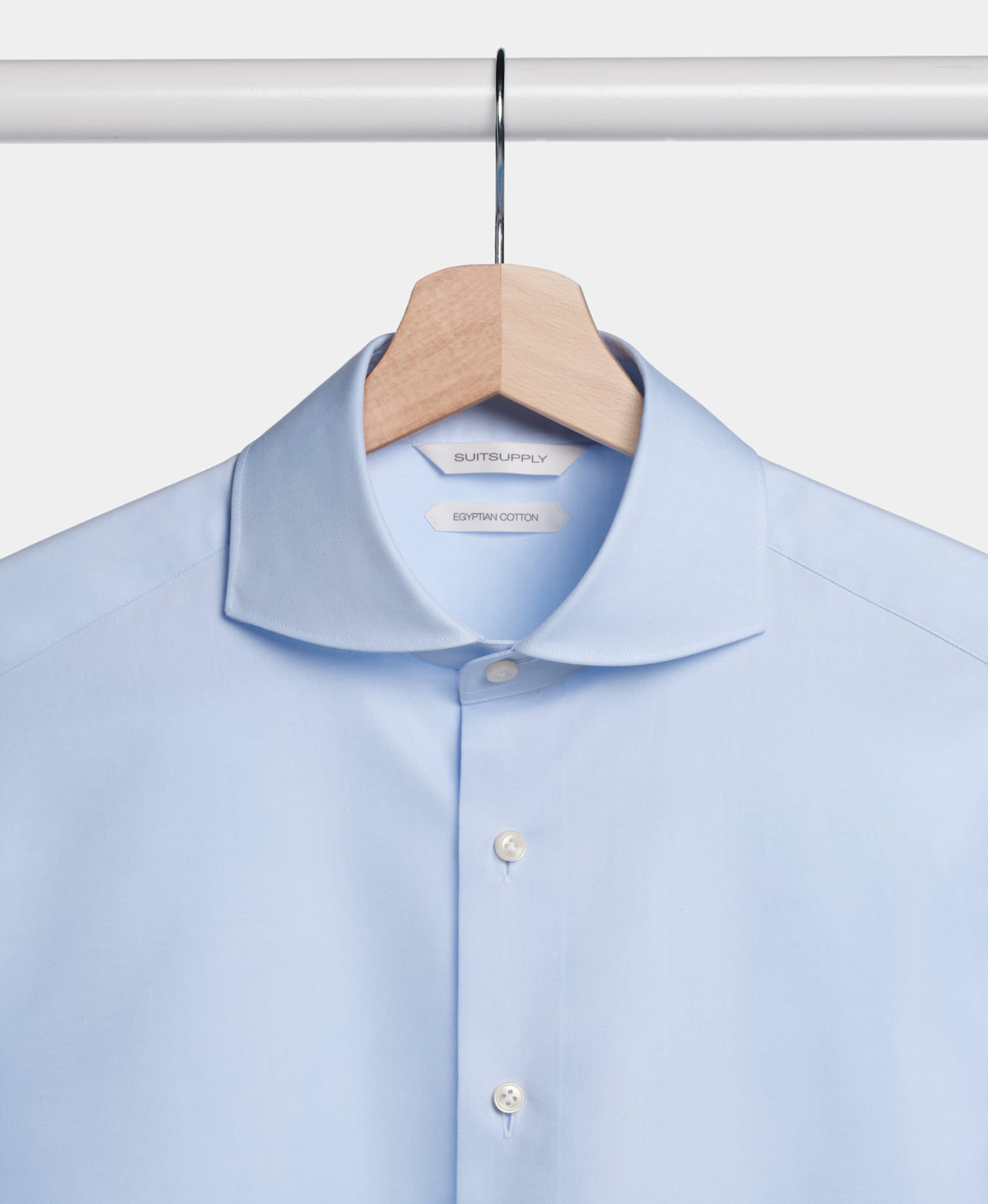 A blue shirt neatly hanging on a hanger, showcasing its vibrant color and smooth fabric.