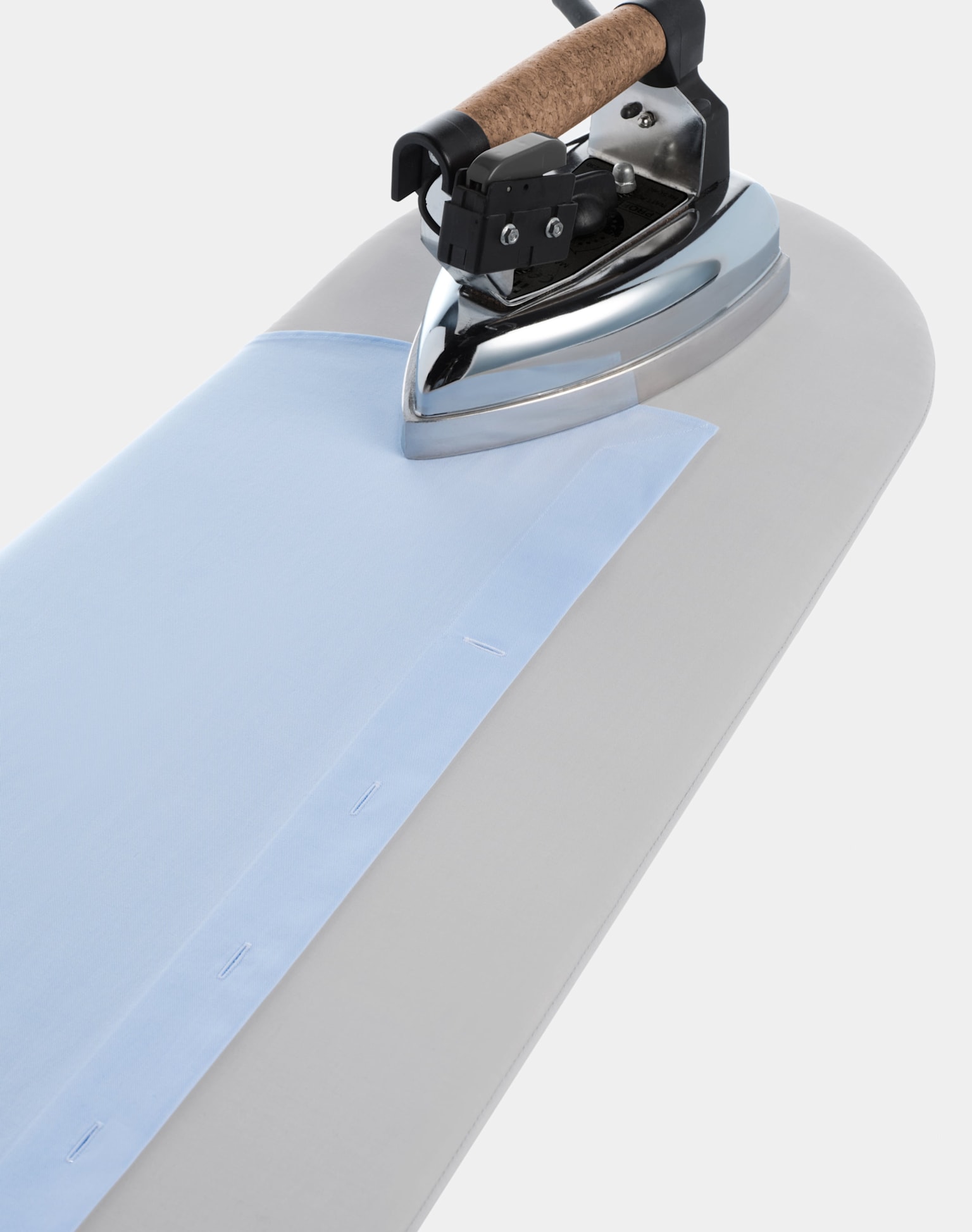  A close-up view of a sleek iron resting on a clean white surface, showcasing its design and features.