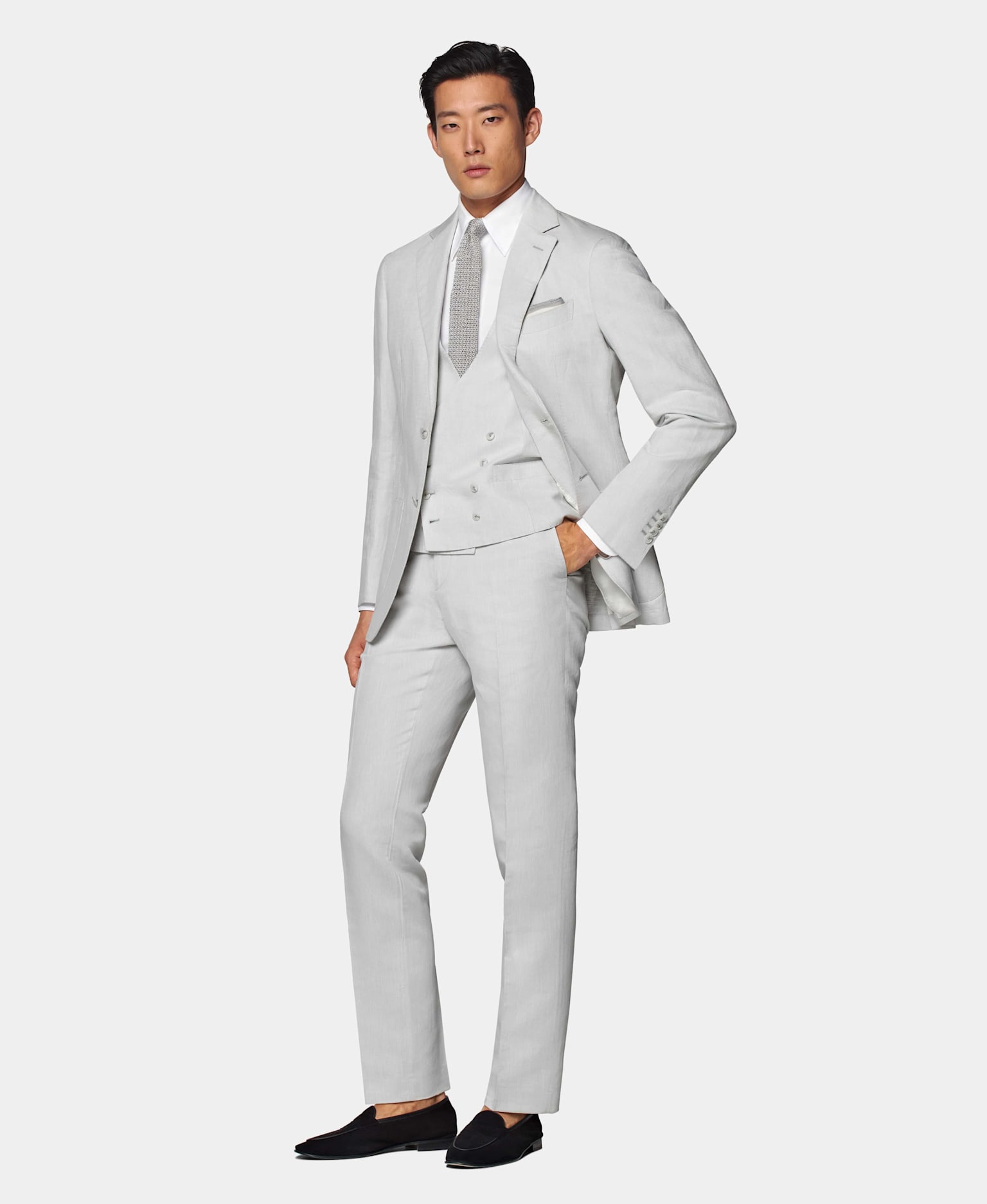 Hellgrauer dreiteiliger Anzug, kombiniert mit weißem Hemd und grauer Fliege aus Seidenstrick.