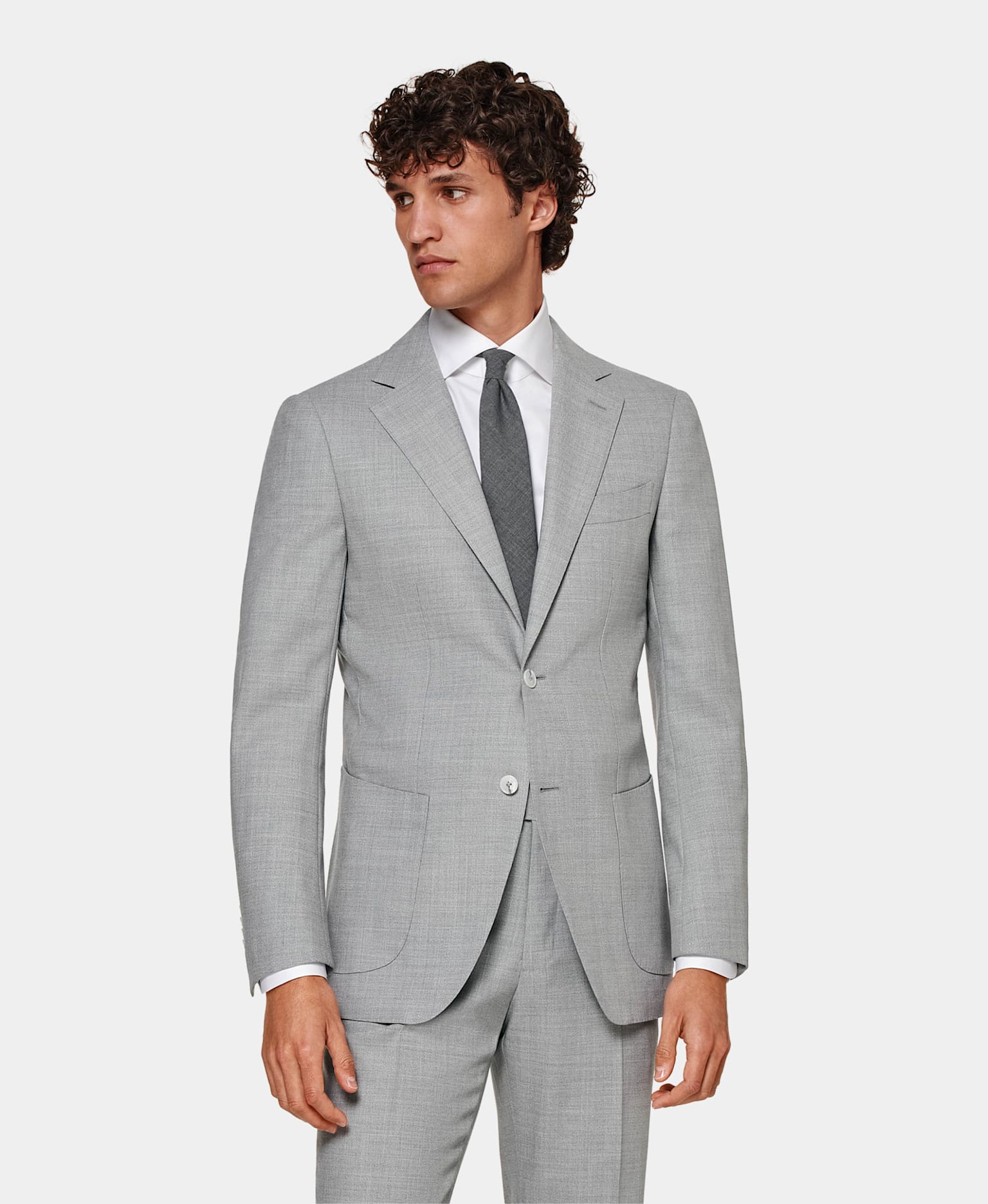 Grey suit with patch pockets, worn with white shirt and grey tie