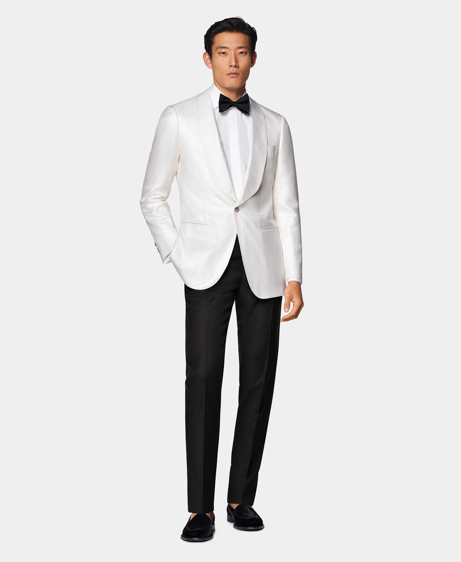Veste de smoking blanche à col châle avec pantalon noir, chemise blanche à gorge cachée et nœud papillon en soie noir.
