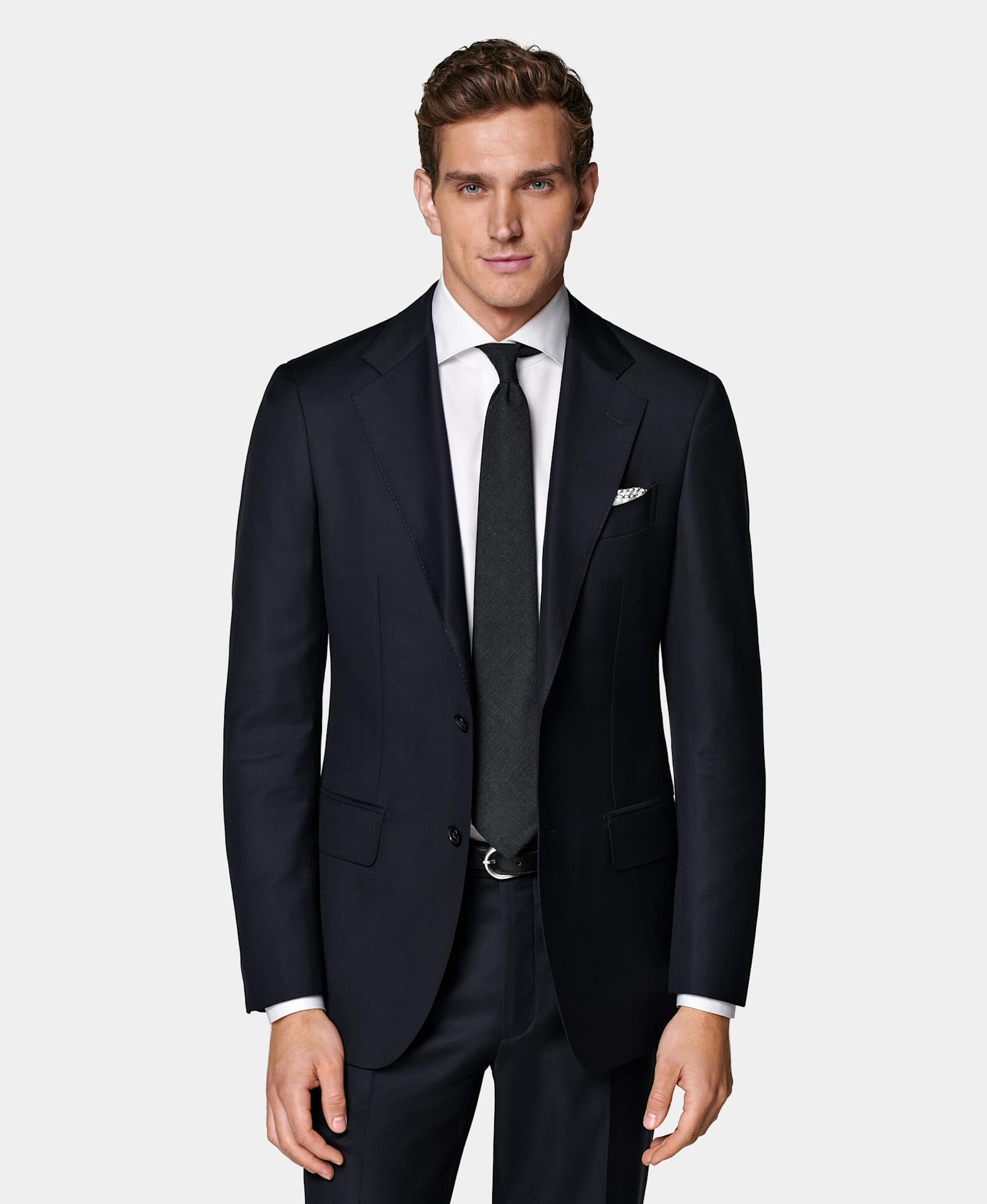 Navy single-breasted suit with shite shirt and navy tie.