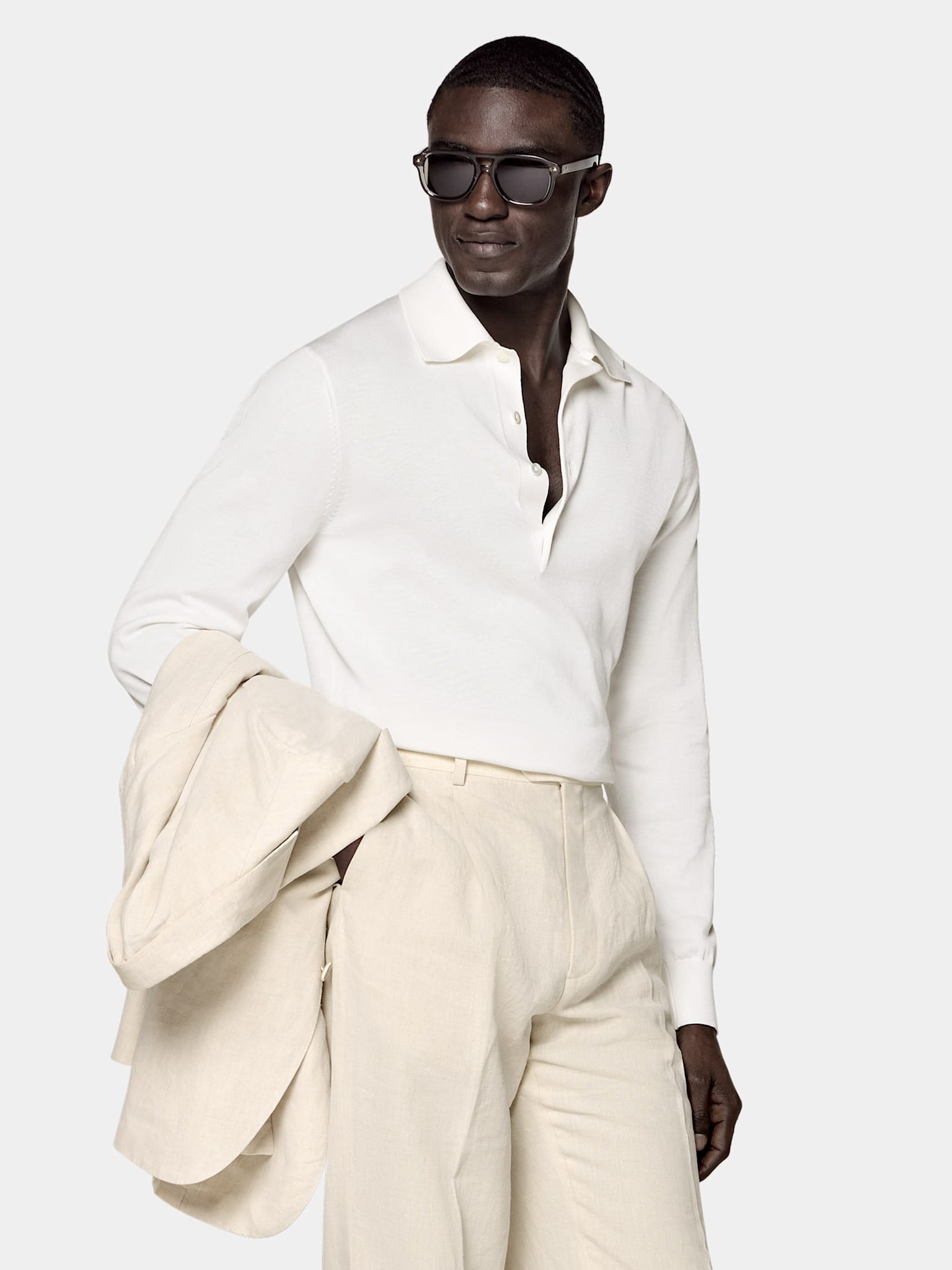White long-sleeve polo styled with beige trousers and jacket
             