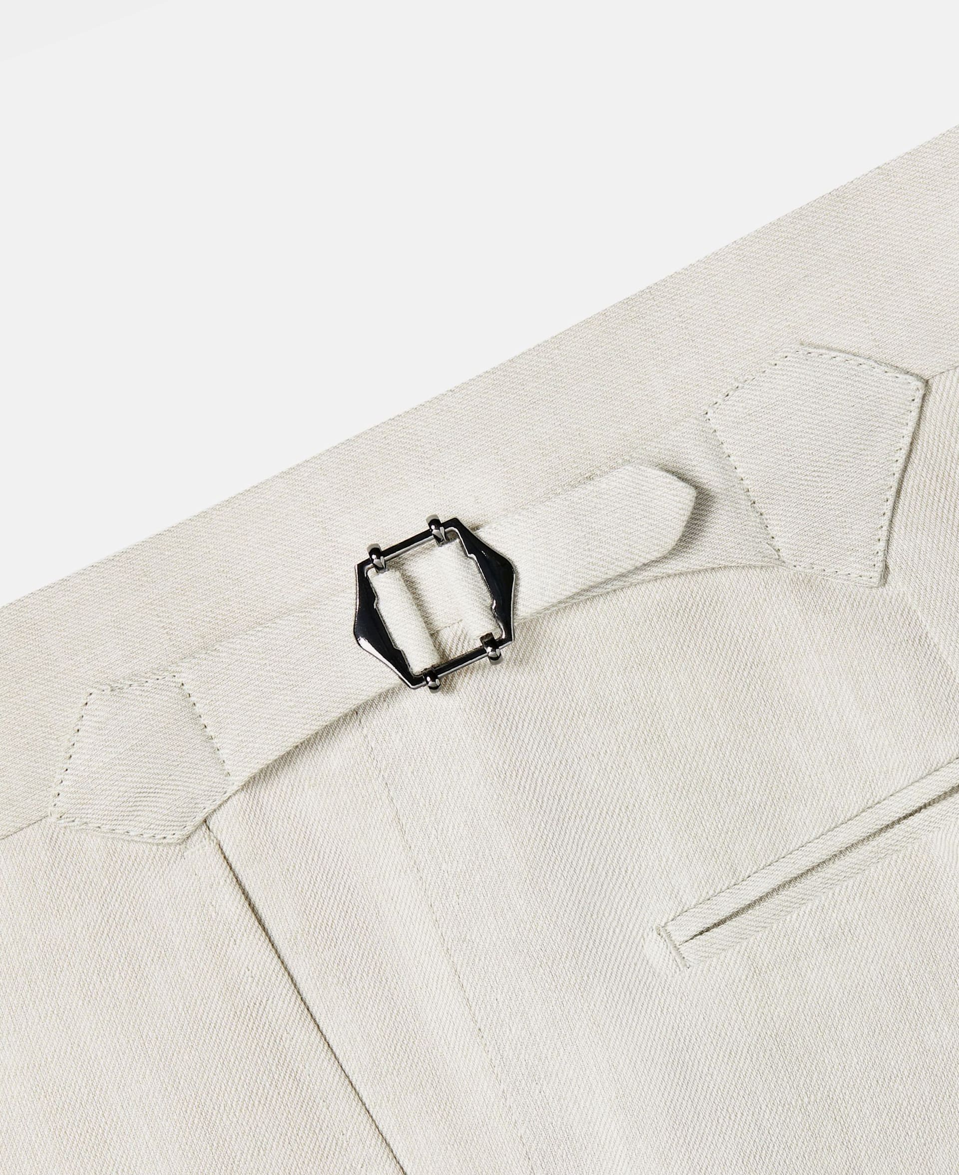 Side adjusters on an off-white linen trouser.