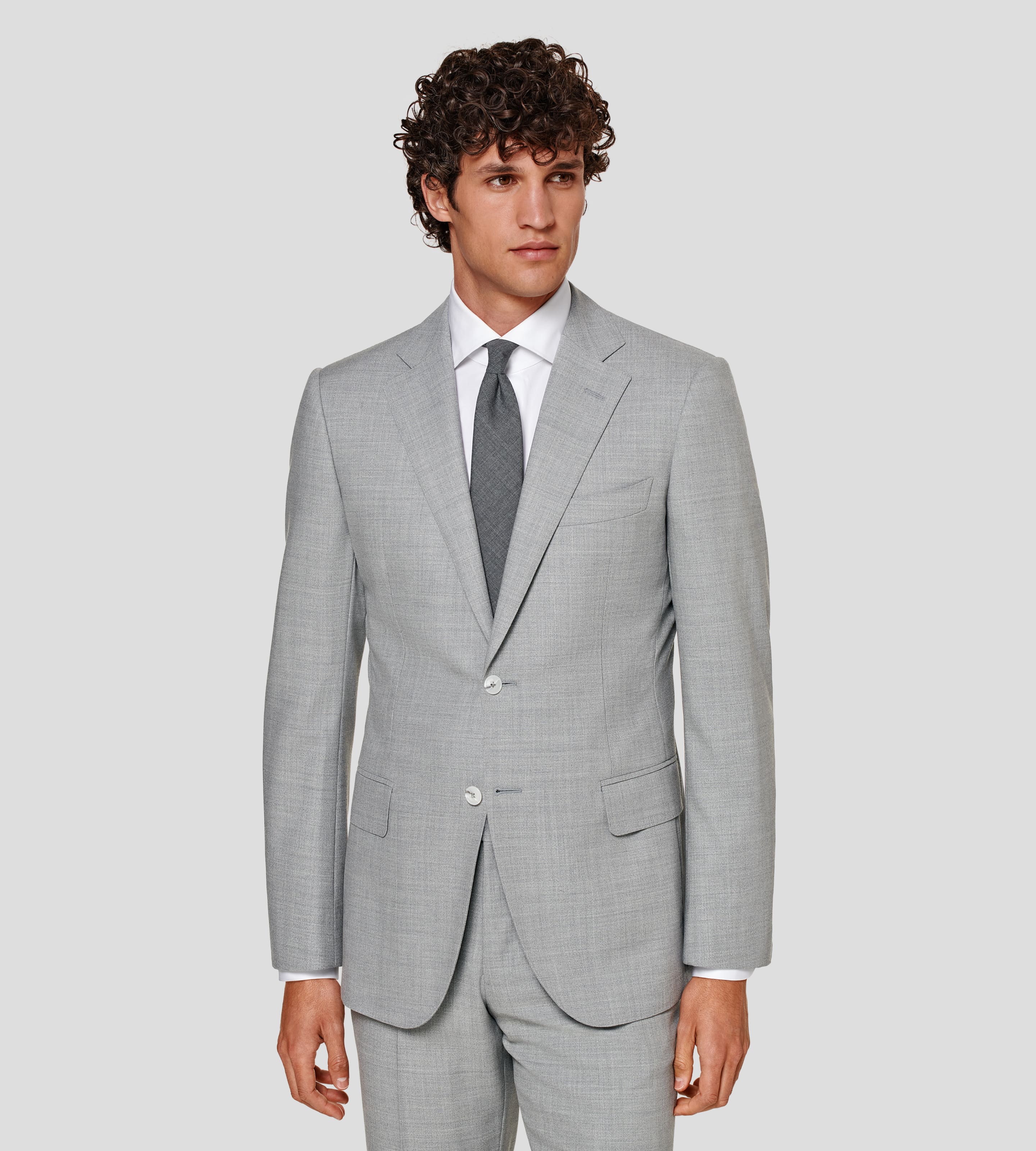 Grey suit with flap pockets and notch lapel, worn with white shirt and grey tie